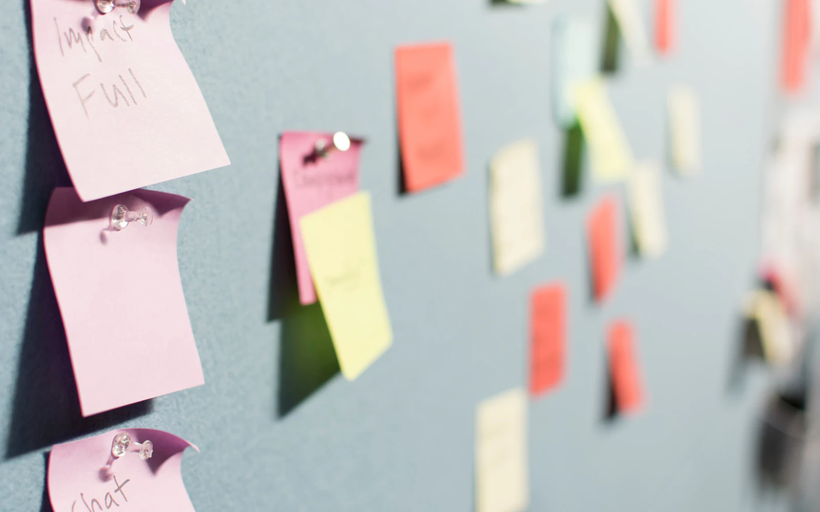 Colorful sticky notes pinned to board