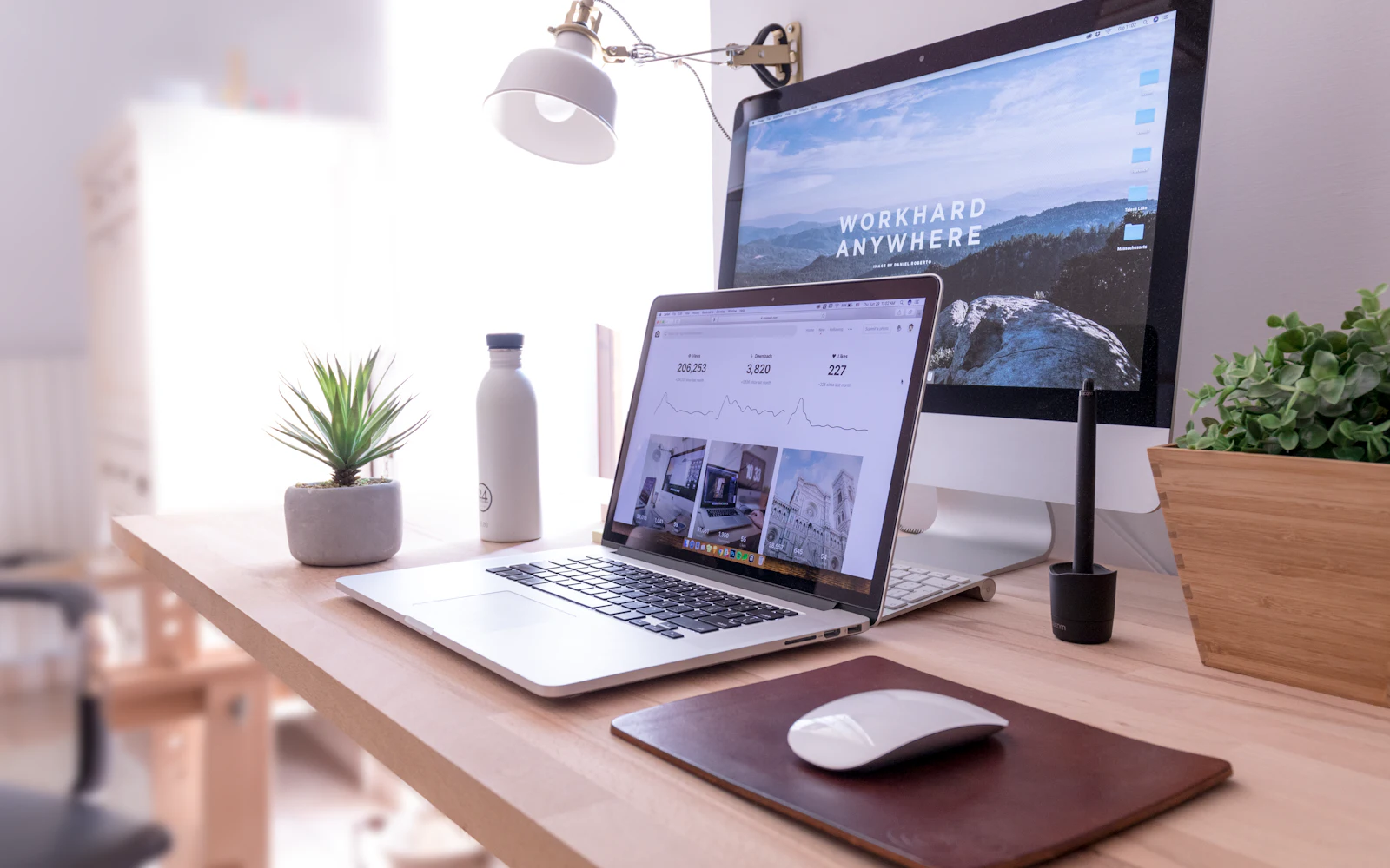 MacBook Pro on table beside white iMac and Magic Mouse