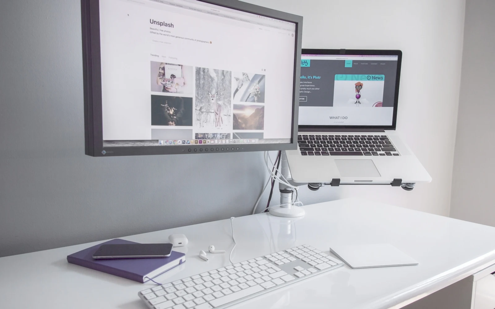 Monitor near MacBook Air on white desk