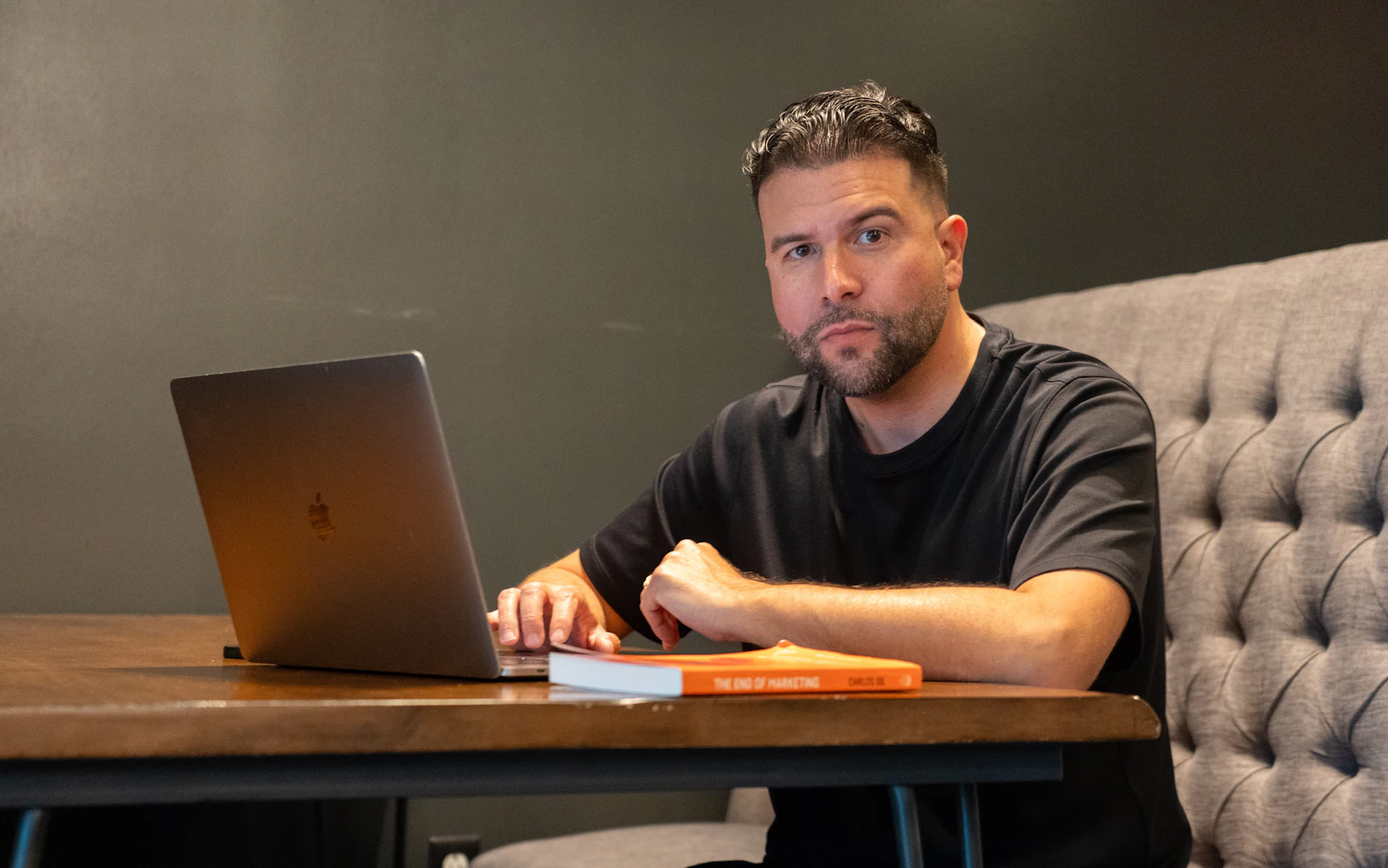 Man using a laptop at a wooden table