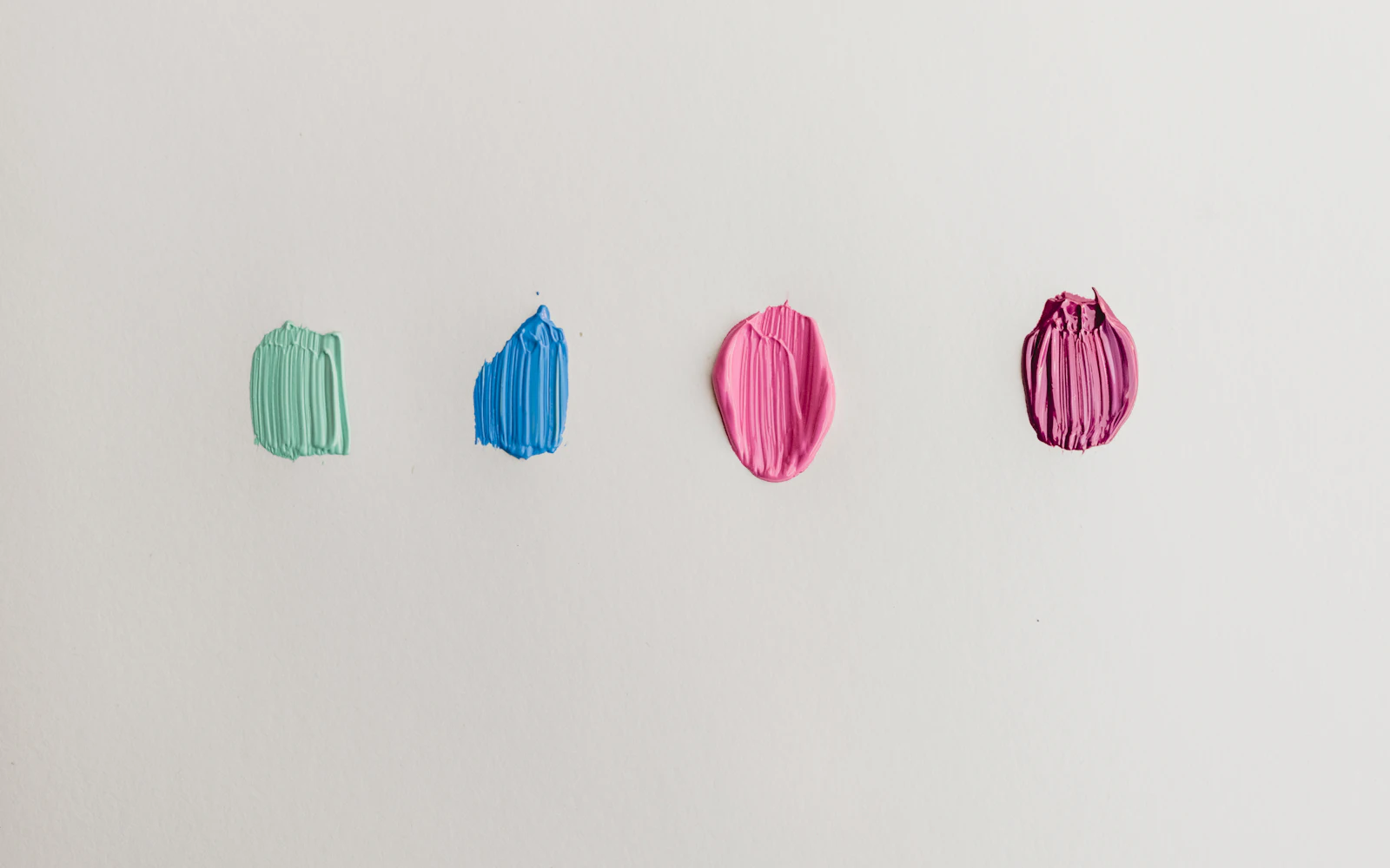 Four green, blue, and pink paints
