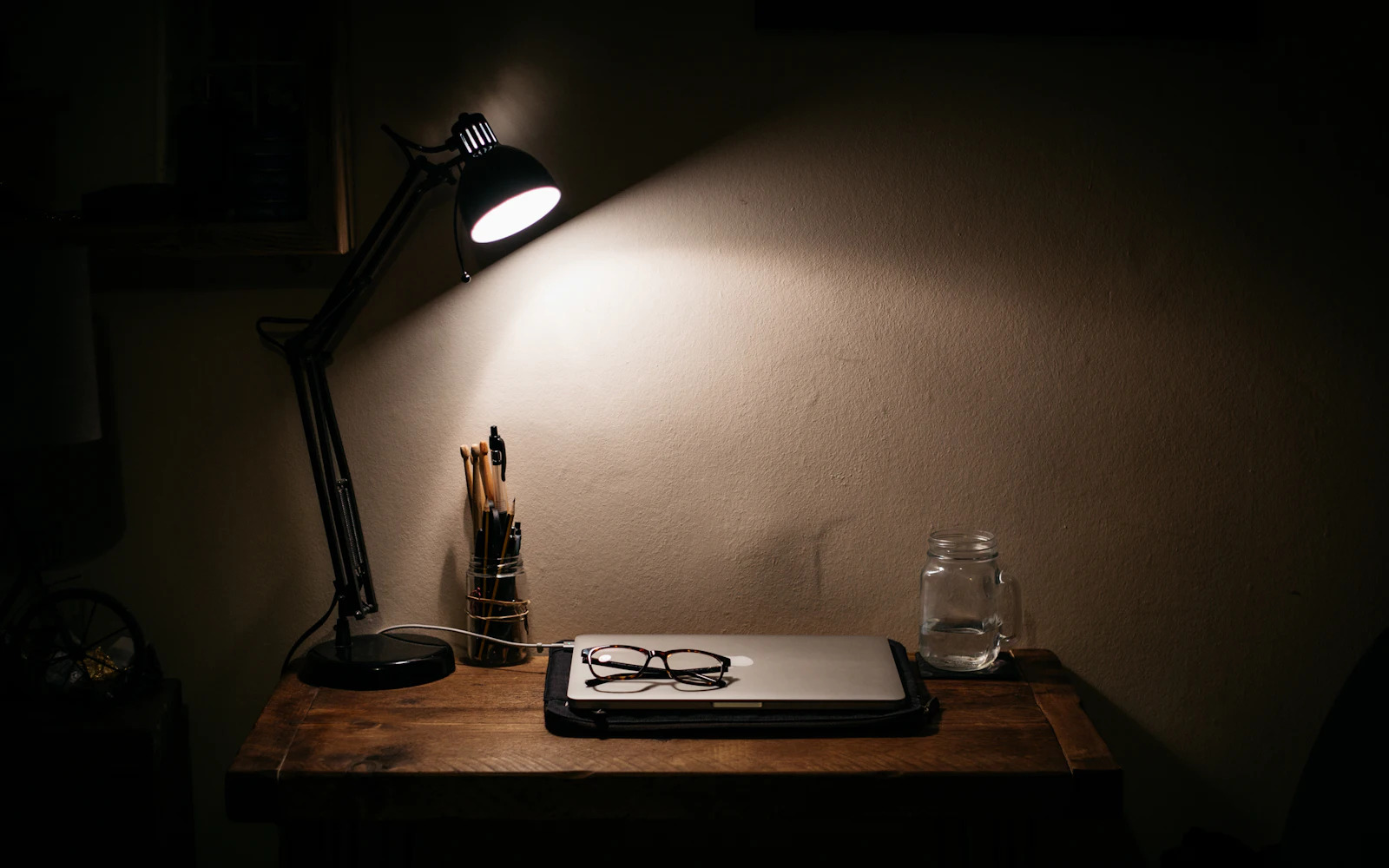 Black desk lamp on a wooden table at night