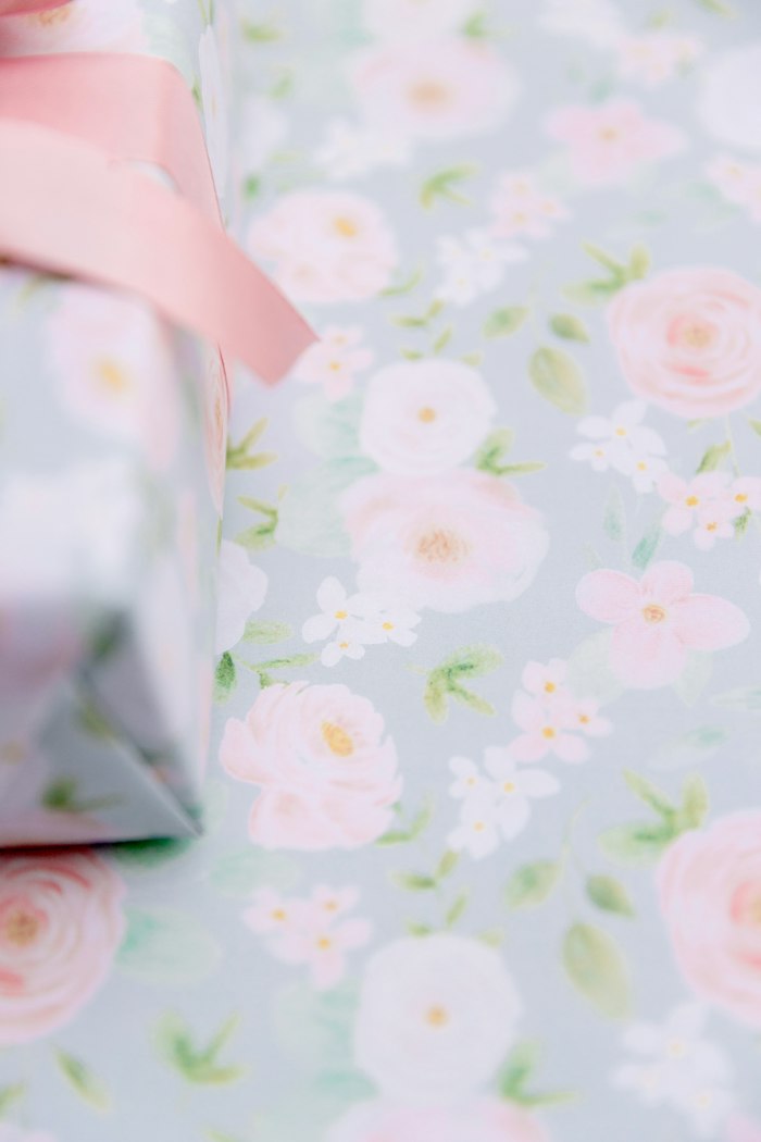 Bloom e-gift card artwork: soft pink and white watercolour florals on a pale blue-grey ground, with a pink ribbon in the corner.