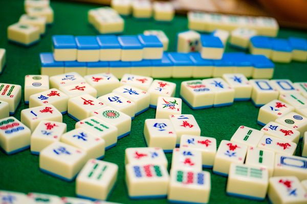 Colourful mahjong tiles spread across green felt.